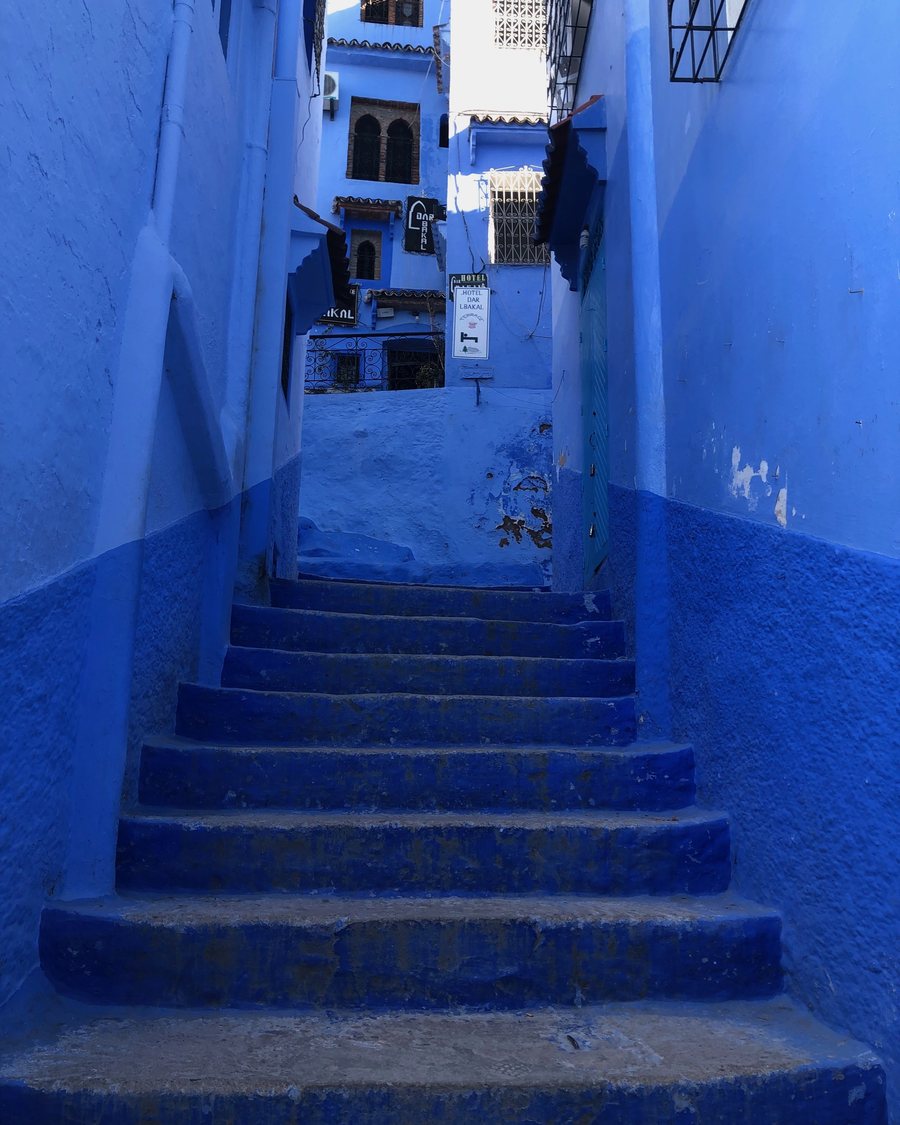 Blue-painted steps climbing between houses in the Chefchaouen medina