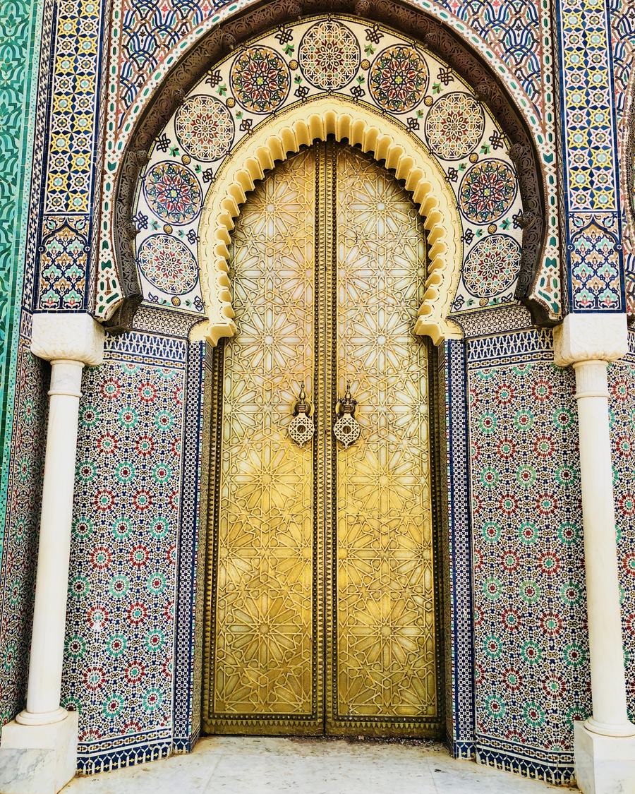The golden brass doors of the Royal Palace at Place des Alaouites, framed by zellige tilework