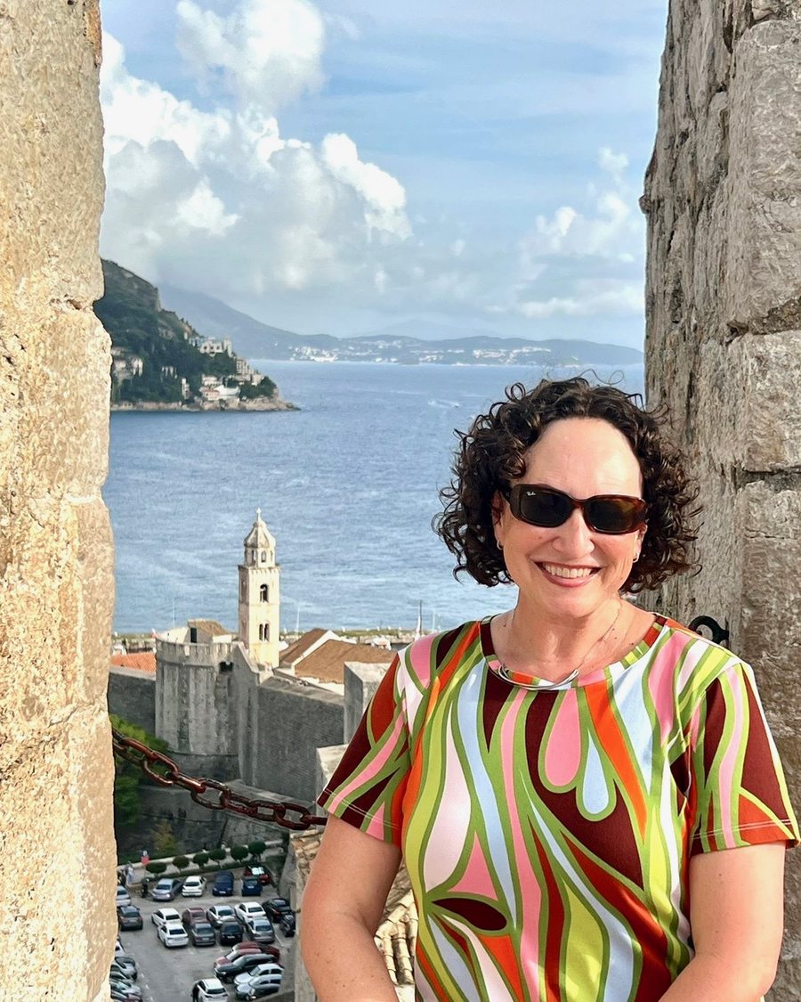 Nicole Sorger on the old city walls above the sea, framed by stone