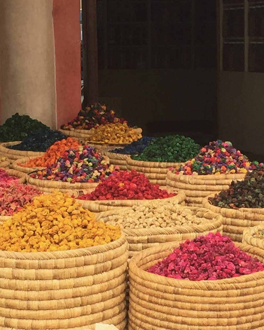 Woven baskets heaped with dried flowers and spices in the souk